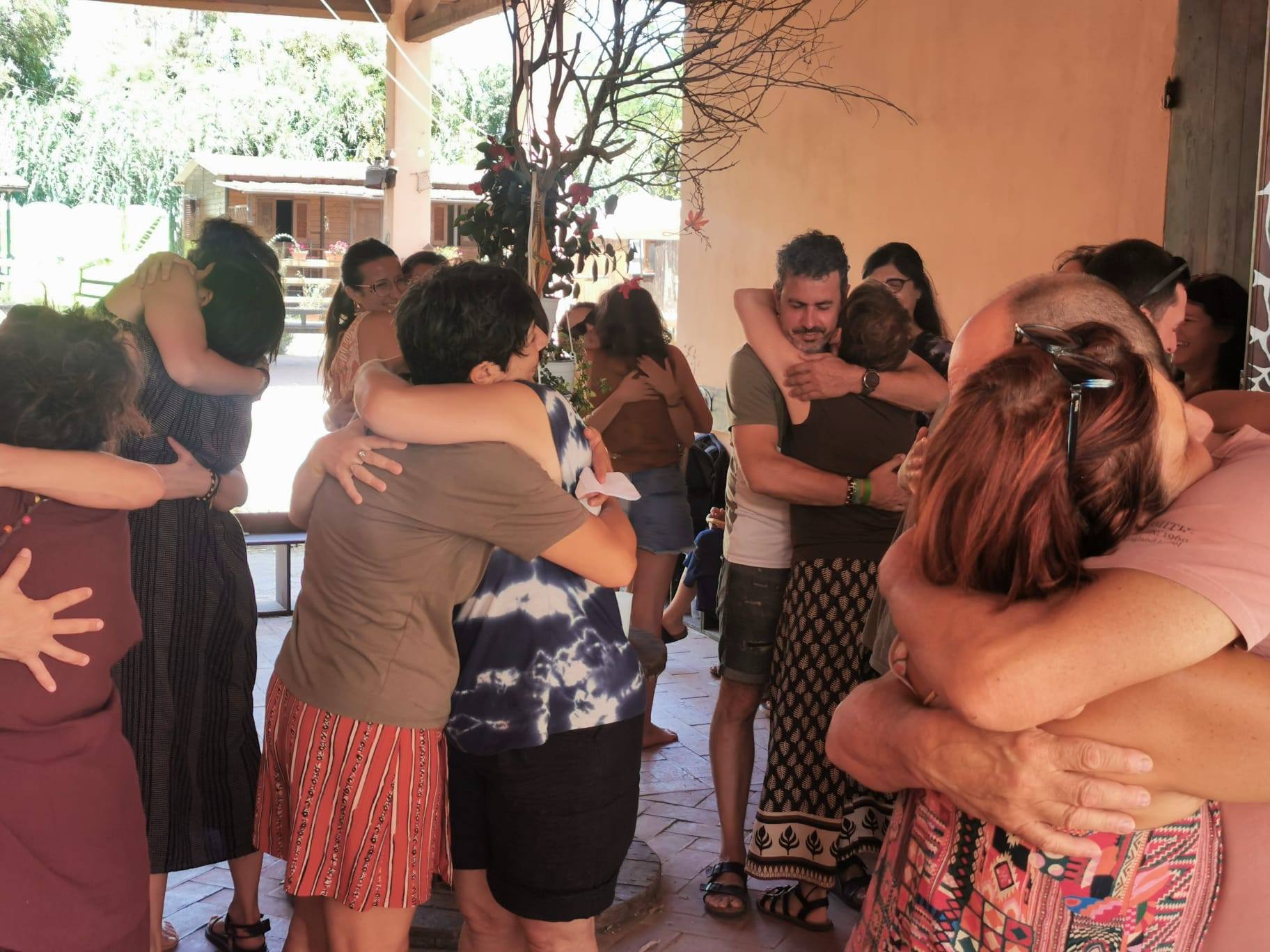 Persone si abbracciano in cerchio durante un incontro